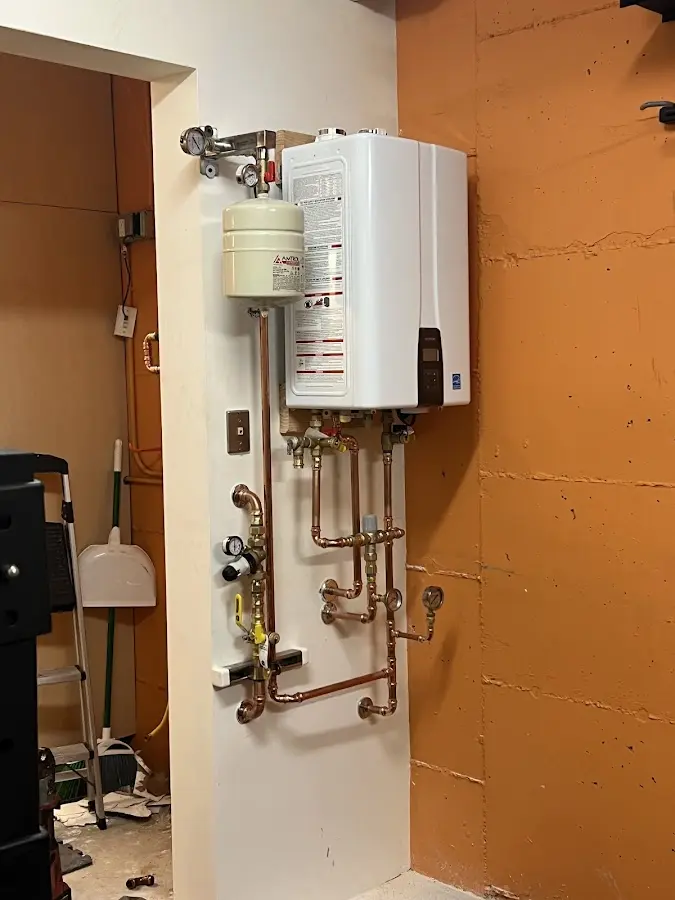 Plumbing technician inspecting water heater connections in Pollock Pines